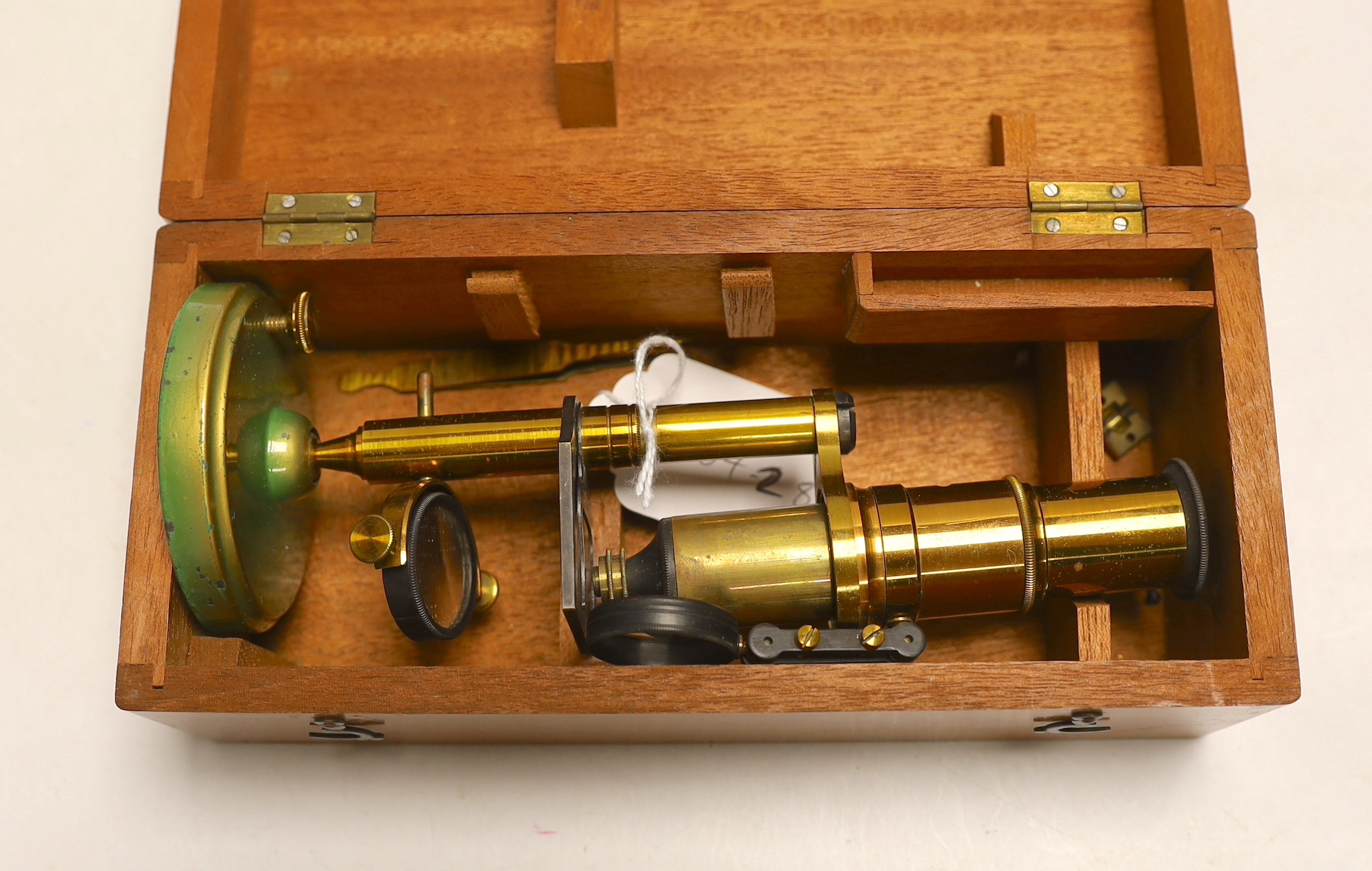 A brass monocular student’s microscope in fitted teak case, case 22cm